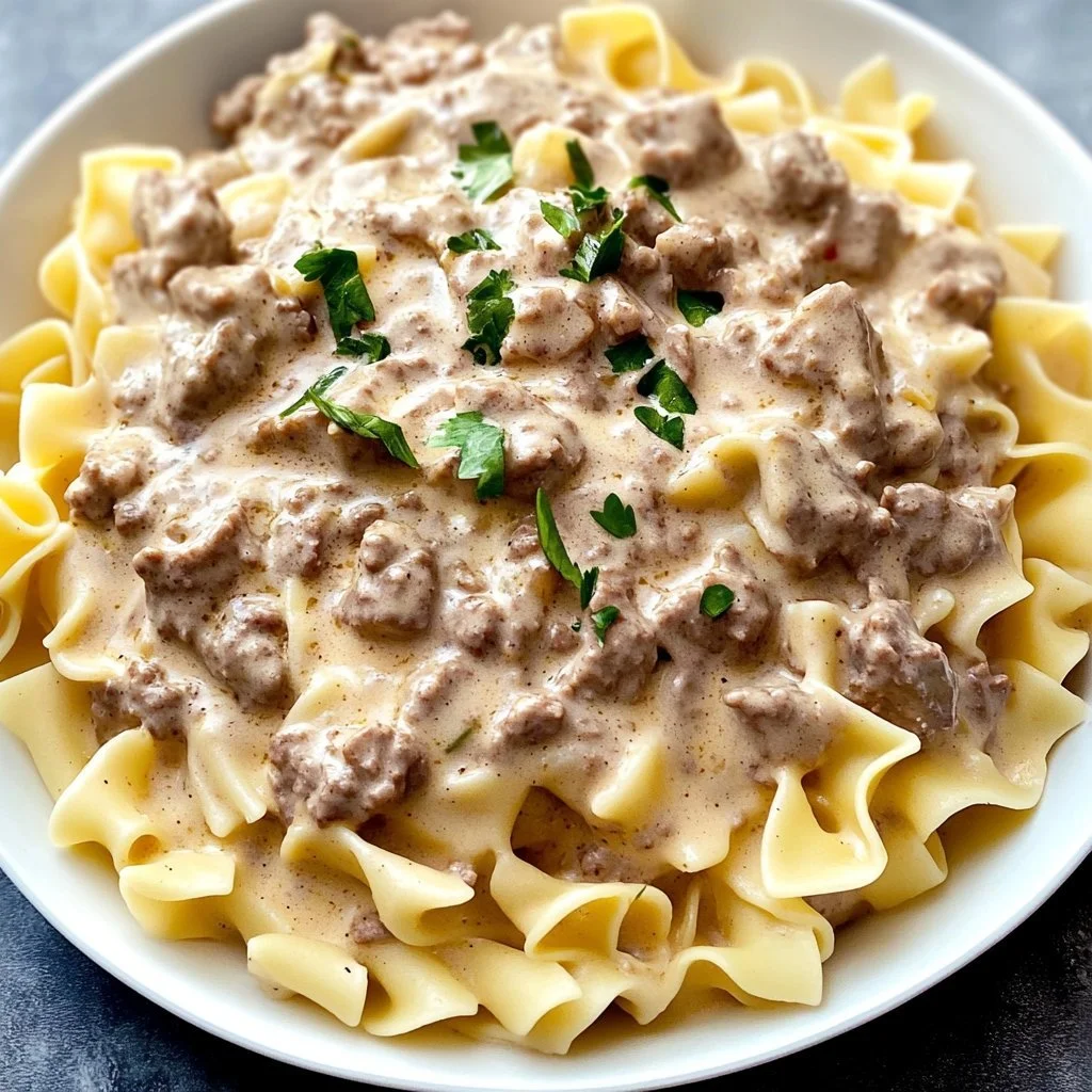 Delicious minced beef stroganoff served with pasta and garnished with parsley.